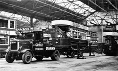 an old black and white photo of trucks in a garage