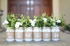 four mason jars with flowers in them sitting on a table