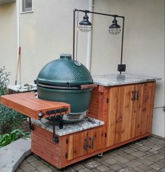 a big green egg sitting on top of a wooden table in front of a building