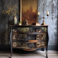 an old dresser with flowers and candles on it