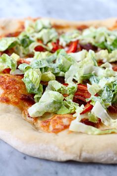 a pizza topped with lettuce and tomato slices