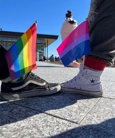 someone is holding a rainbow flag on their feet