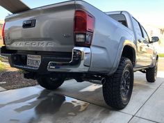 the rear end of a silver truck parked in a driveway