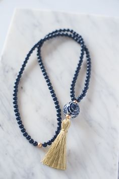 A ginger jar-inspired porcelain bead is accented by navy resin beads and a handmade metallic gold tassel. Necklace Length: 20.25 in. (includes tassel) Handmade in Charleston, South Carolina. Basket Gifts, Hand Painted Beads, Necklace Ideas, Tassel Jewelry, Ginger Jar, Charleston South Carolina, Resin Beads, Classic Gold, Ginger Jars