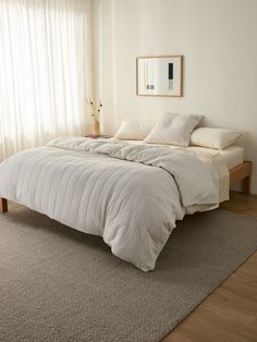 a white bed sitting on top of a wooden floor