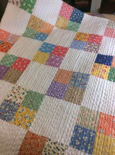 a multicolored quilt is laying on the floor