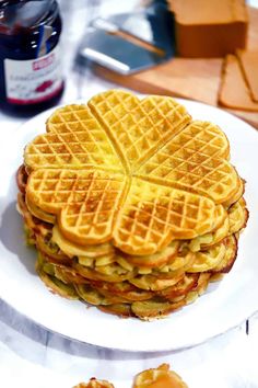 a stack of waffles sitting on top of a white plate next to butter