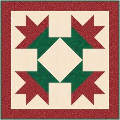 a red and green quilt with an arrow design on the center, in front of a white background