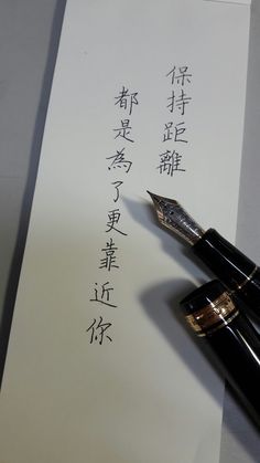 a fountain pen sitting on top of a piece of paper with writing in chinese characters