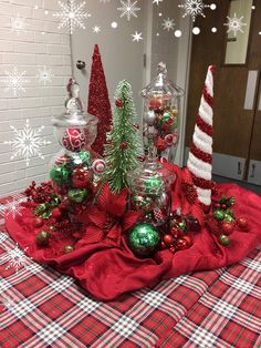 a table topped with christmas decorations and candy canes on top of a checkered table cloth