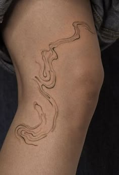 a woman's leg with a tattoo on it that is shaped like a snake