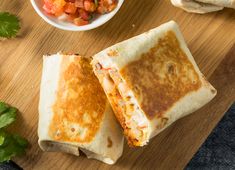 two quesadillas cut in half on a cutting board next to a bowl of salsa