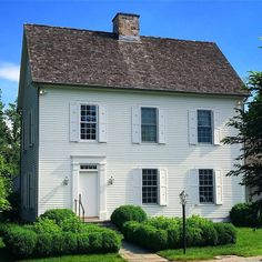 a white two story house with a brown roof