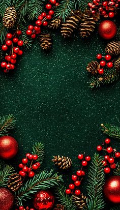 christmas decorations and pine cones are arranged on a dark green background with red berries, evergreen leaves and pine cones