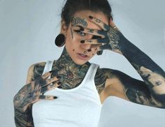 a woman with tattoos covering her face and hands