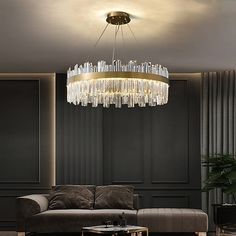 a living room with a couch, coffee table and chandelier hanging from the ceiling