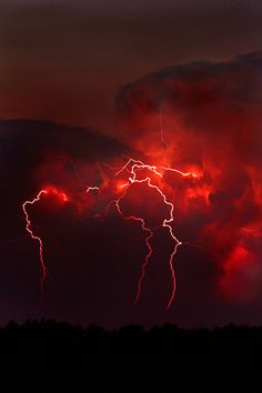 the sky is filled with bright red clouds and lightning