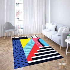 a living room filled with furniture and a colorful rug on top of a hard wood floor