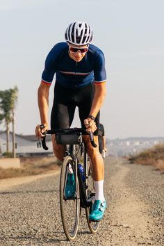 a man riding a bike down a dirt road