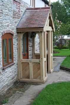 a small wooden building sitting next to a brick wall