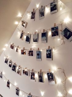 a christmas tree made out of pictures and lights is hung on the wall with string lights