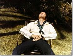 a man sitting on top of a metal bench