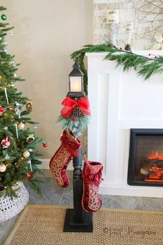 a christmas tree with stockings hanging from it and a lit candle in front of the fireplace