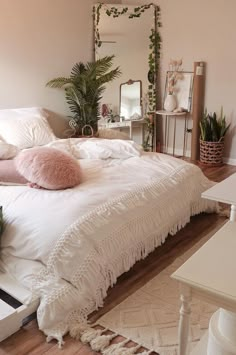 a white bed sitting in a bedroom on top of a hard wood floor