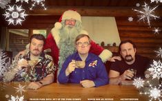 three men sitting at a table in front of a santa clause holding a cup and looking into the camera