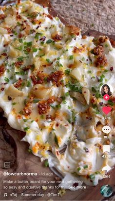 a wooden cutting board topped with food on top of a stone counter next to a cell phone