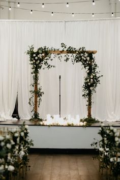 an outdoor ceremony with white flowers and greenery on the altar, surrounded by candles