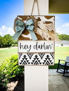 a wooden sign that says hey darvin hanging from the side of a building with two bows on it