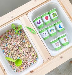 two trays filled with cereal and plastic cups on top of a wooden table next to each other