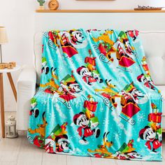 a mickey mouse christmas blanket on a couch