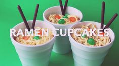 three plastic cups filled with ramen cupcakes on top of a green background