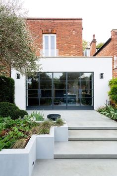 an outdoor space with steps leading up to the front door, and plants on either side