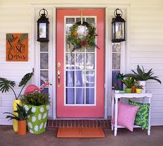 the front door is decorated with plants and decorations