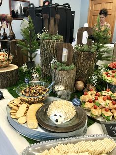 an assortment of snacks are displayed on a buffet table with people in the background looking at them