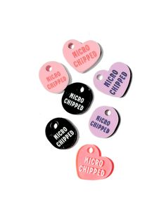 five heart shaped tags with the words micro chipped in pink, white and black