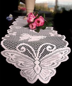 a white table runner with pink roses on it