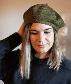 a woman with long hair wearing a green hat