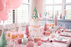 a table set for a party with pink and white decorations, balloons, and cake