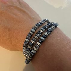 a close up of a person's arm wearing two bracelets on their wrist