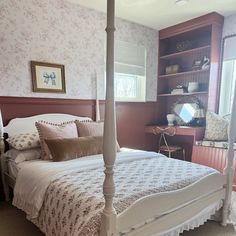 a white bed sitting in a bedroom next to a window