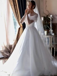 a woman in a wedding dress is posing for the camera with her hand on her face