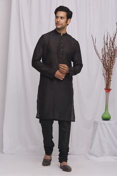 Black kurta with geometric print and front buttons. Paired with churidar.
Component: 2
Pattern: Printed
Type Of Work: Geometric
Neckline: Mandarin
Sleeve Type: Full Sleeves
Fabric: Semi Silk Moonga, Cotton Silk
Color: Black
Other Details: 
Front buttons
Occasion: Sangeet - Aza Fashions Straight Kurta In Cotton Silk With Dabka Detail, Straight Cotton Silk Kurta With Dabka, Navratri Cotton Silk Bandhgala Kurta, Bollywood Style Black Designer Kurta, Black Cotton Silk Salwar Kameez For Eid, Cotton Silk Kurta For Puja During Transitional Season, Black Designer Kurta For Navratri, Handloom Cotton Silk Kurta, Black Cotton Silk Designer Sets