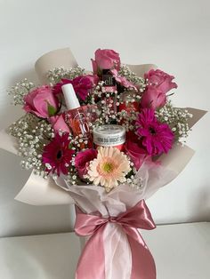 a bouquet of pink flowers and white baby's breath are wrapped in a pink ribbon