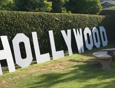 the hollywood sign is displayed in front of a hedged area with a picnic table and bench