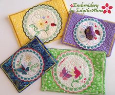 four embroidered coasters with flowers and butterflies on them