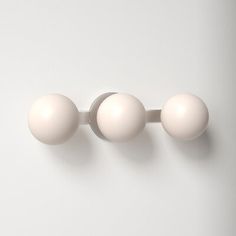 three white balls mounted to the side of a wall